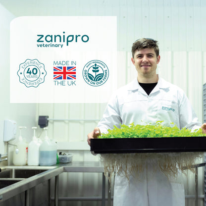 Person in a lab holding a tray of herbs with Zanipro branding in the background.